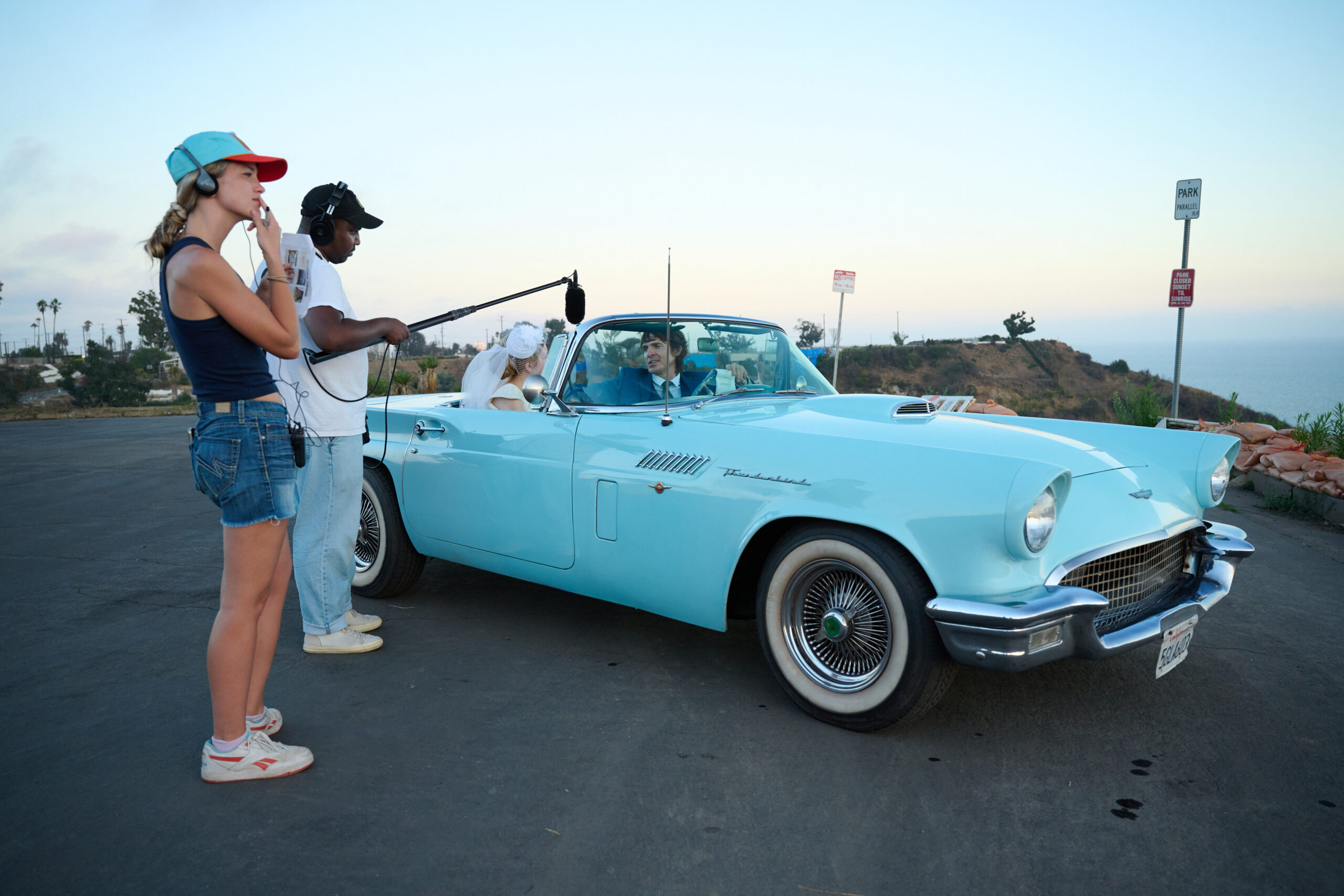 Baby blue 1950s thunderbird convertible with actors sitting inside filming proof of concept for the movie The Golden Trail